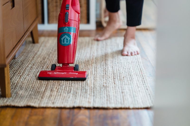 Vacuuming a rug in a bright living room